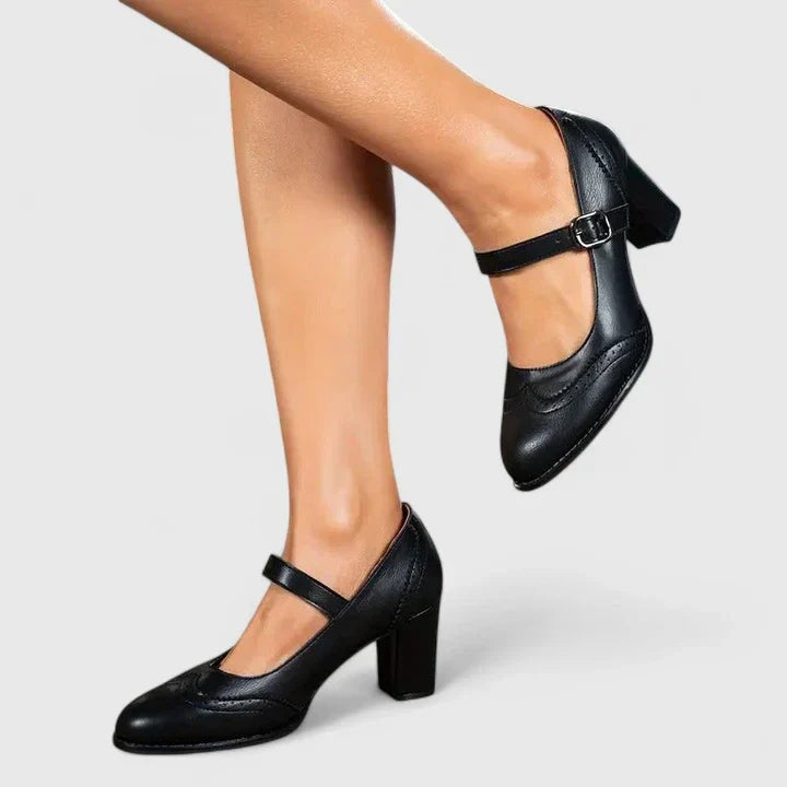 Black leather Mary Jane pumps with ankle strap worn on model's feet