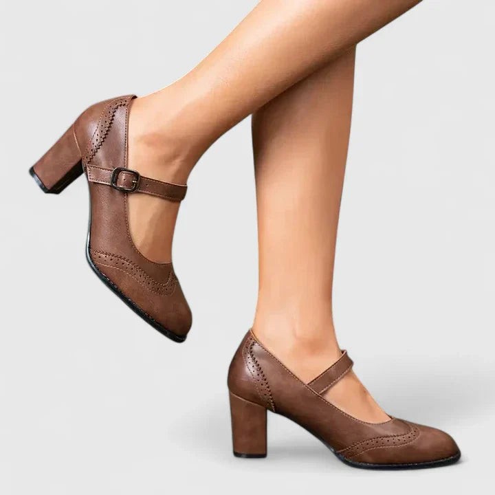 Brown leather Mary Jane block heel pumps with buckle strap on model's feet