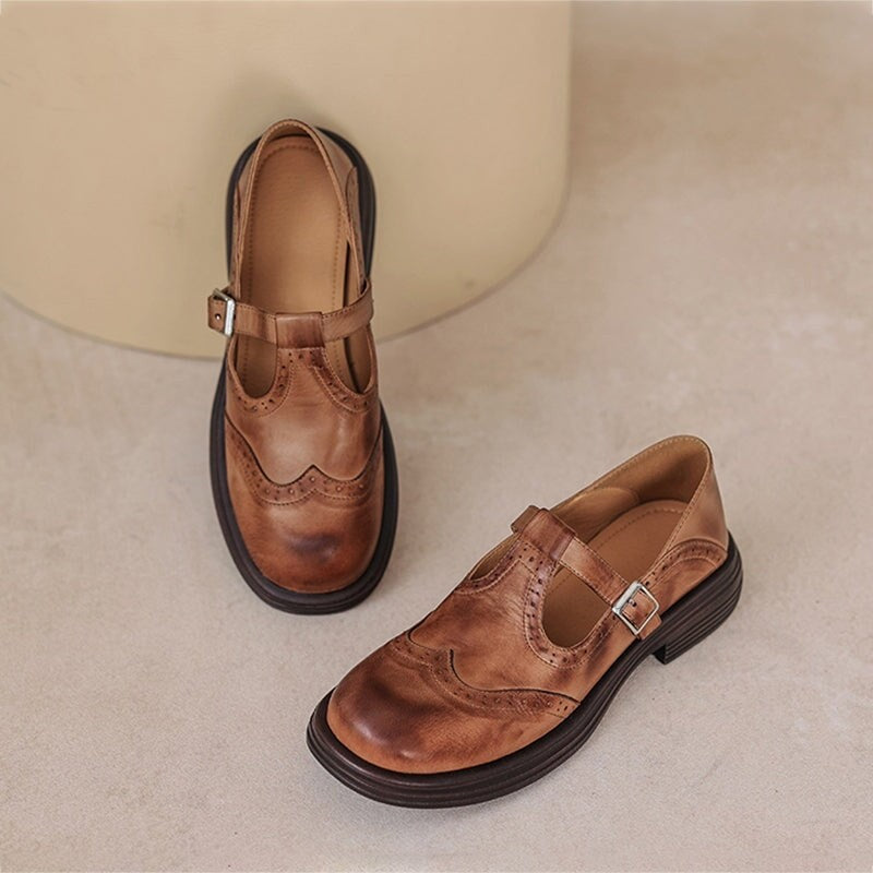 pair of brown leather brogue Mary Jane shoes with buckle strap on beige stool