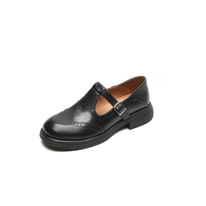 black leather T-strap Mary Jane shoe with brogue perforations, side view
