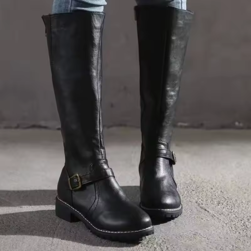 Front view of black knee-high boots with buckle strap and rounded toe