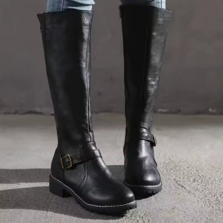 Front view of black knee-high boots with buckle strap and rounded toe