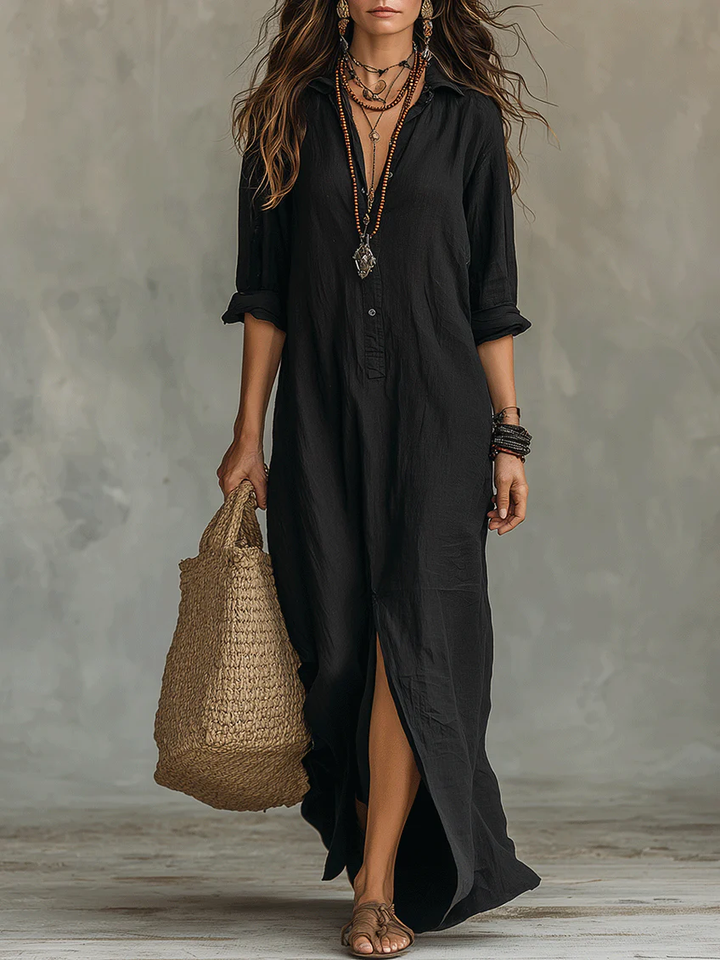 Black button-front maxi shirt dress with collar and side slit, paired with a straw tote