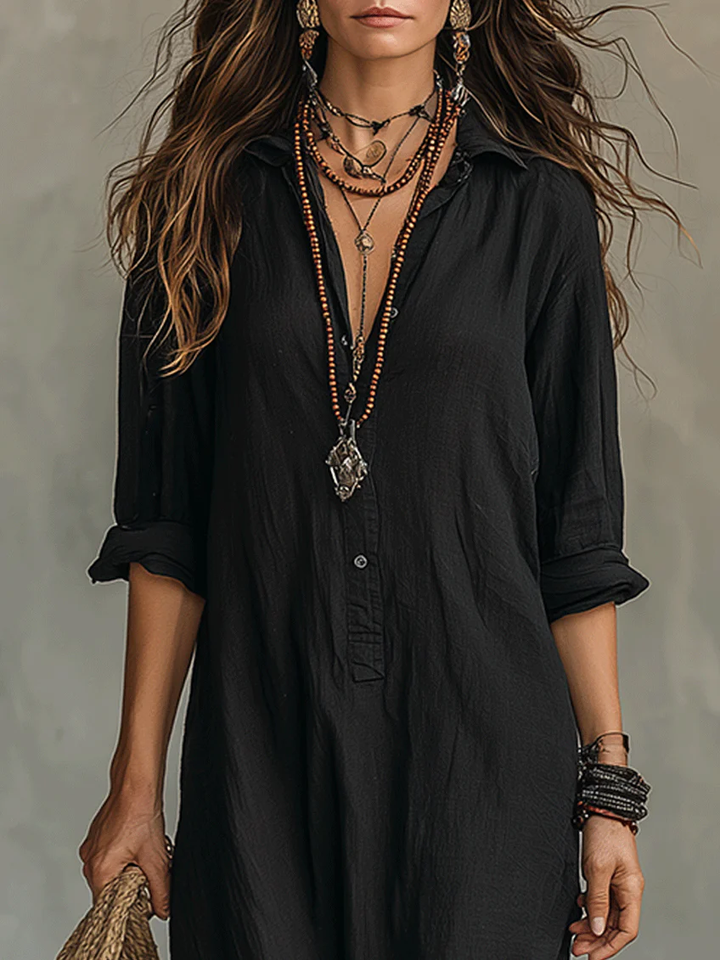 Close-up of black shirt dress collar and button placket with layered boho necklaces
