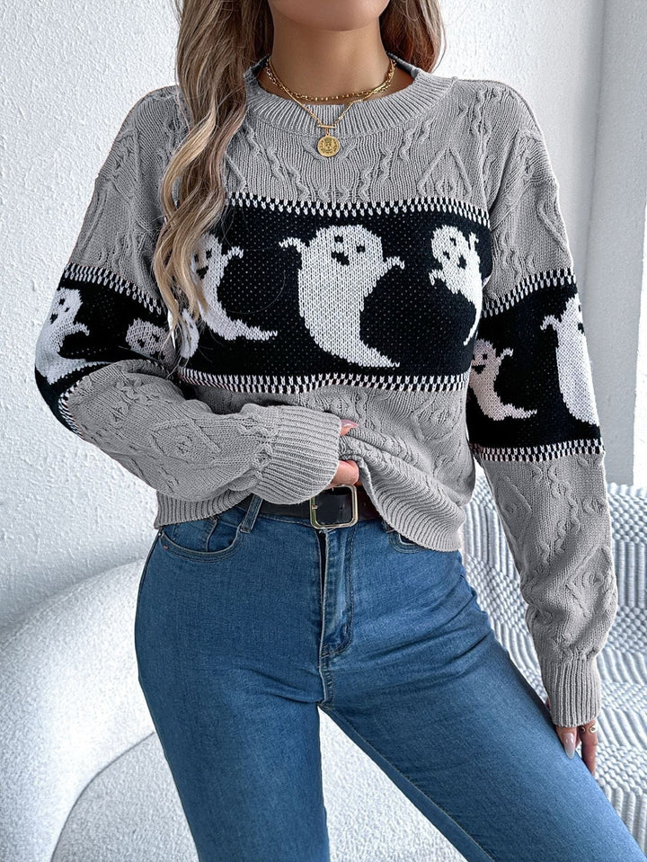 Gray cable-knit crew neck sweater with ghost print band, worn with jeans