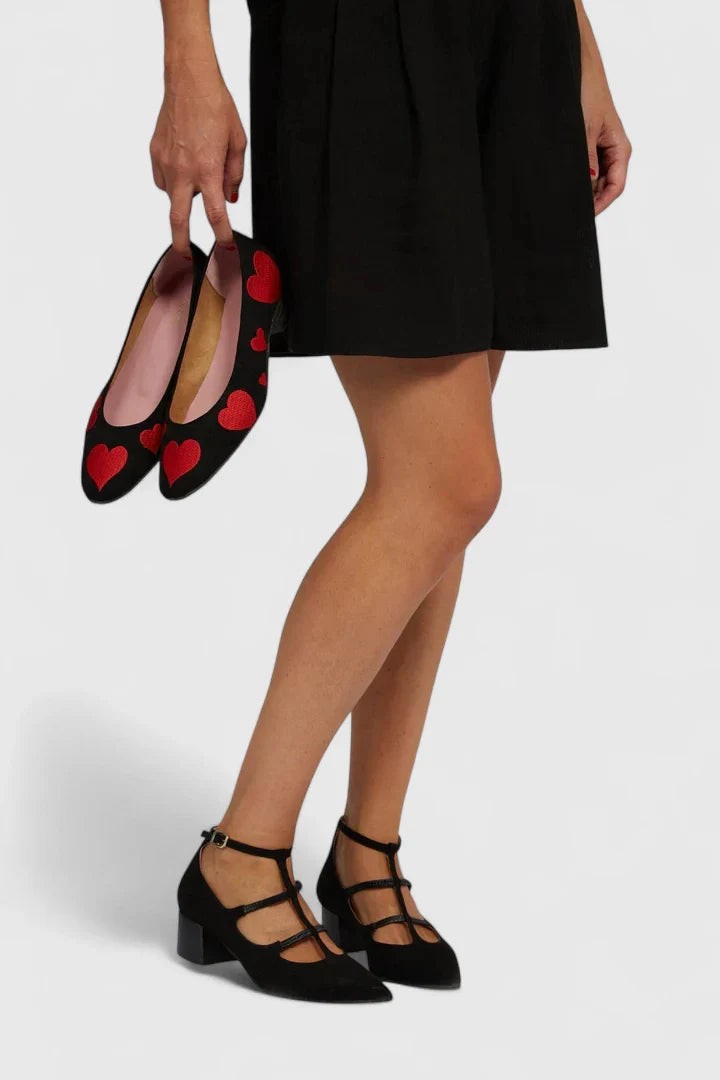 black suede pumps with red heart embroidery and ankle strap detail