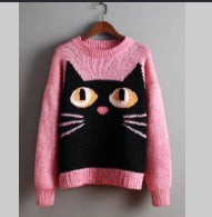 pink knit sweater with black cat face and whisker graphic