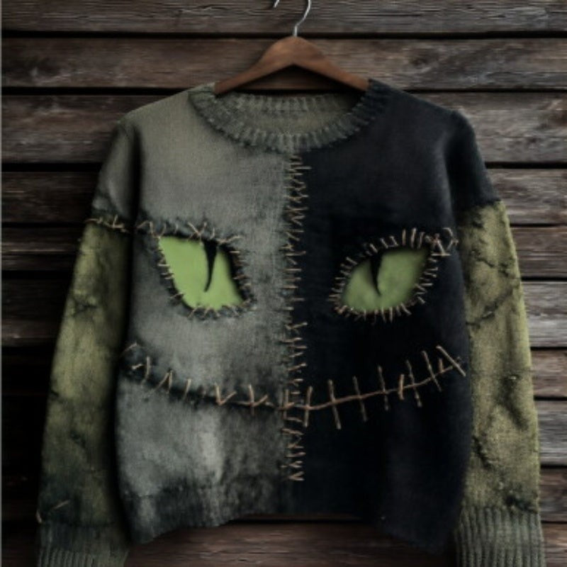 olive and black distressed sweater with stitched cat-eye monster design