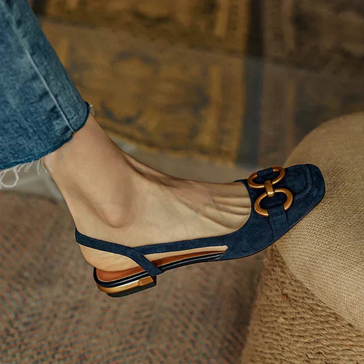 Close-up of navy suede slingback flat with gold chain link accent