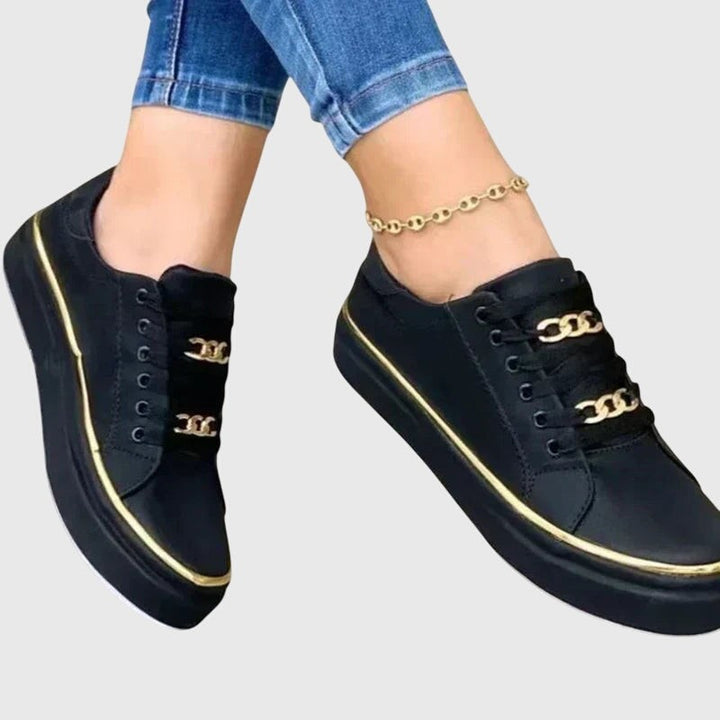 Black leather sneakers with gold chain lace detail and platform sole