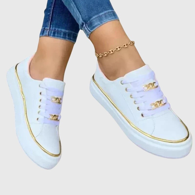 White platform sneakers featuring gold chain accent and metallic trim