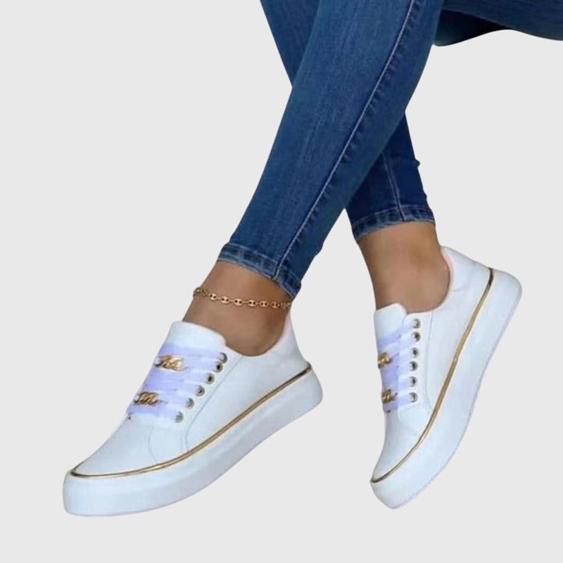White lace-up sneakers with gold chain trim and thick platform sole