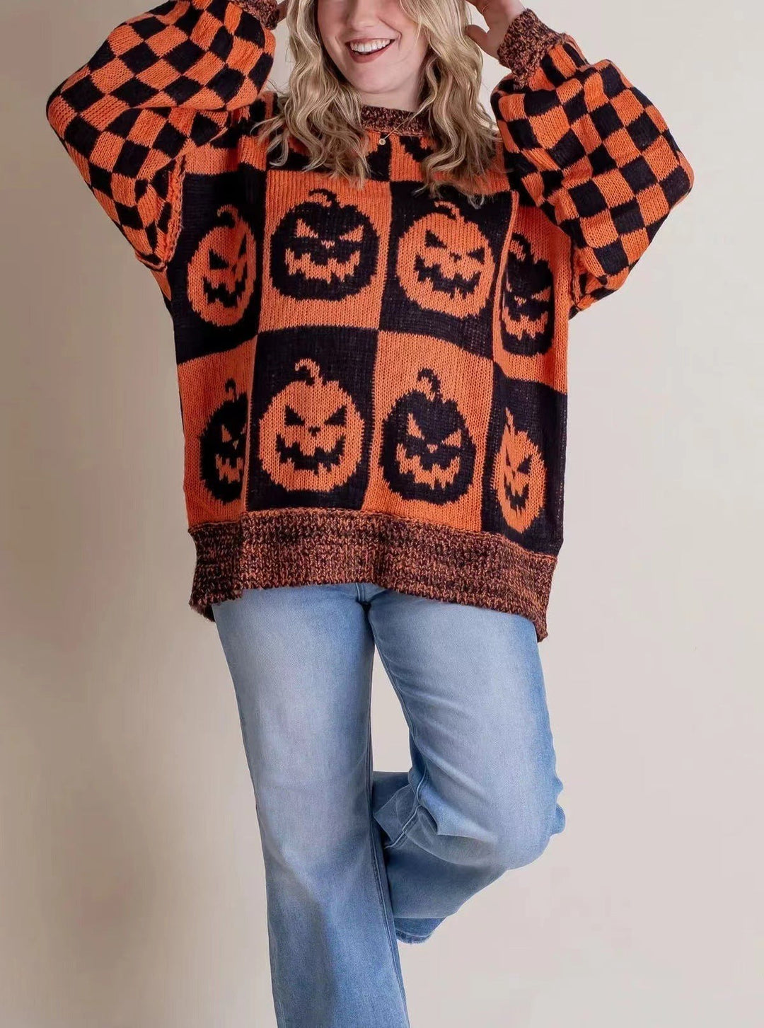 orange and black checkered sweater featuring jack-o-lantern pumpkin print