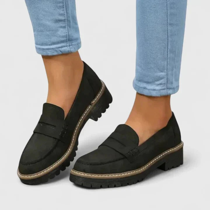 Black suede penny loafers with chunky lug sole and stitched trim