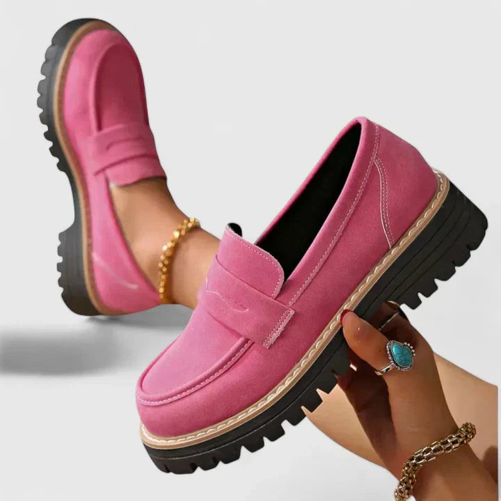 Pink suede platform loafers featuring black lug sole and topstitching