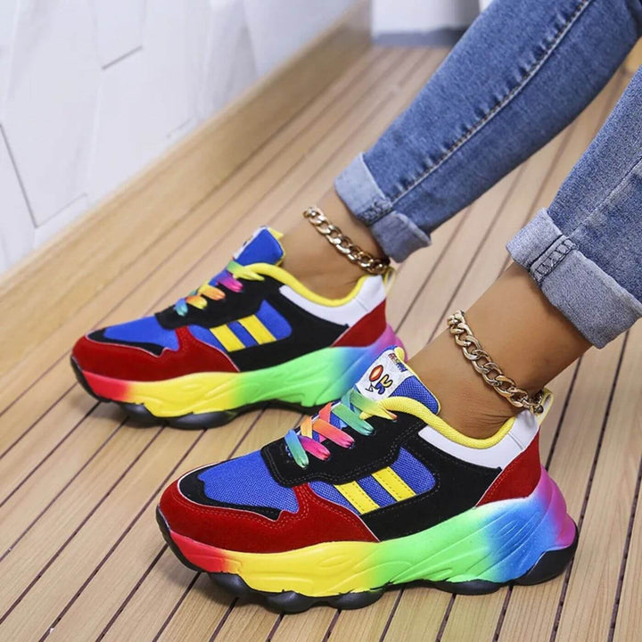 Rainbow chunky sneakers with red suede toe and blue mesh upper, worn with cuffed jeans