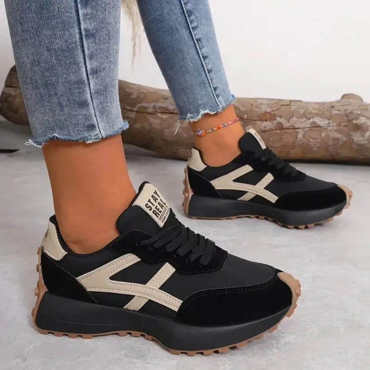 black chunky sneakers with beige panel accents and lugged rubber sole