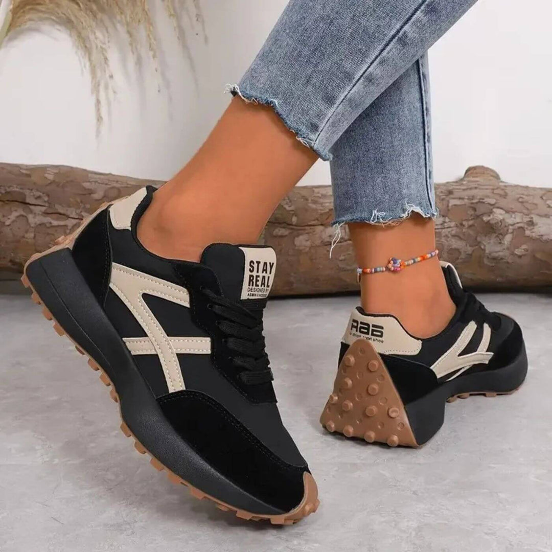 black platform sneakers with cream accents and gum lug outsole, rear view