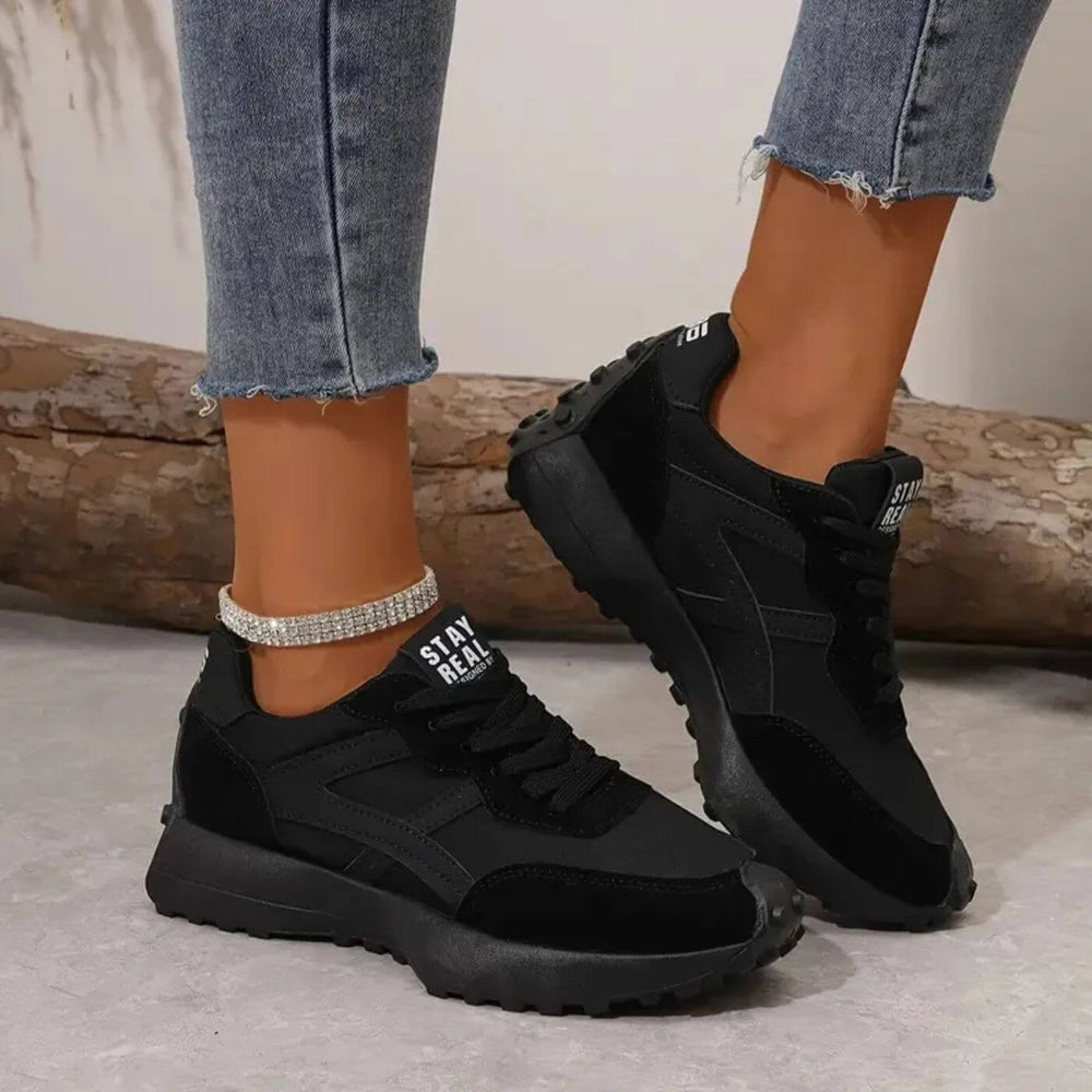 All-black chunky platform sneakers styled with cropped denim and rhinestone anklet