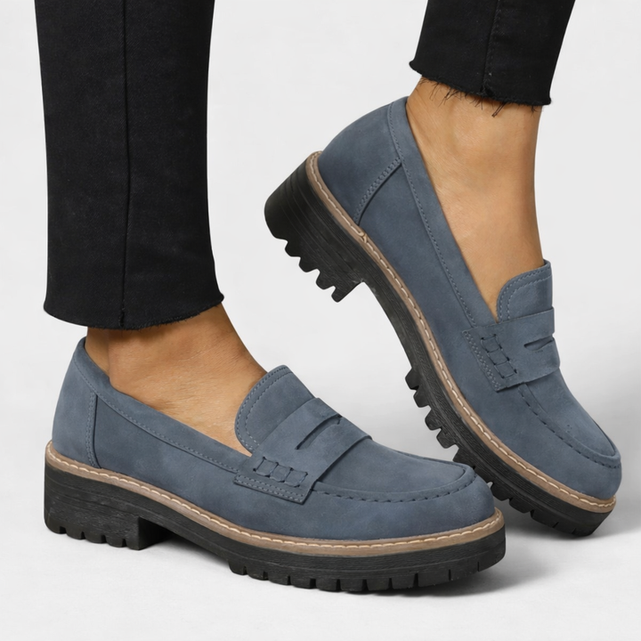 slate blue suede penny loafers with thick lug sole worn with black jeans