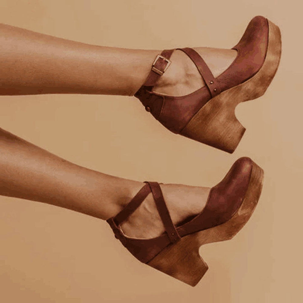 Brown leather closed-toe wedges featuring crisscross straps and chunky wooden heel
