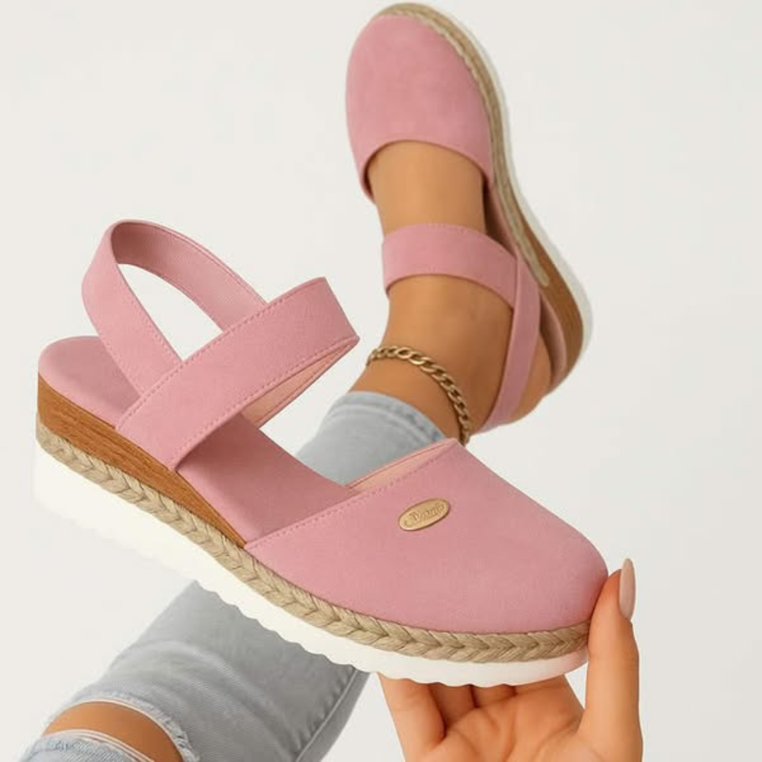 Pink closed-toe wedge sandal featuring elastic crisscross straps and jute trim
