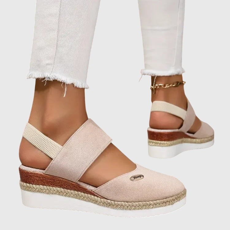Cream suede platform sandal featuring crisscross elastic straps and jute sole
