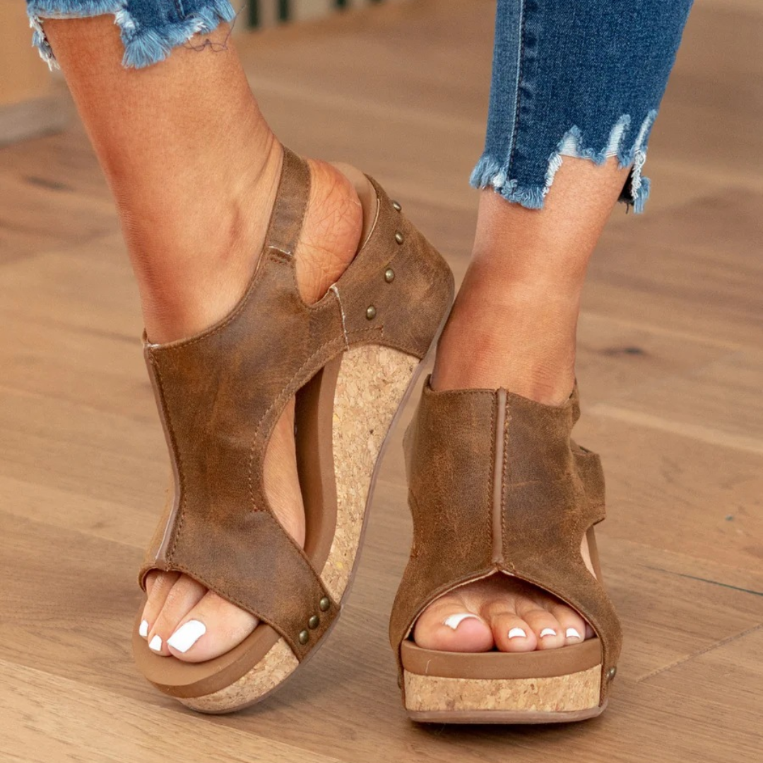 Distressed brown wedge sandals featuring buckle ankle strap closure