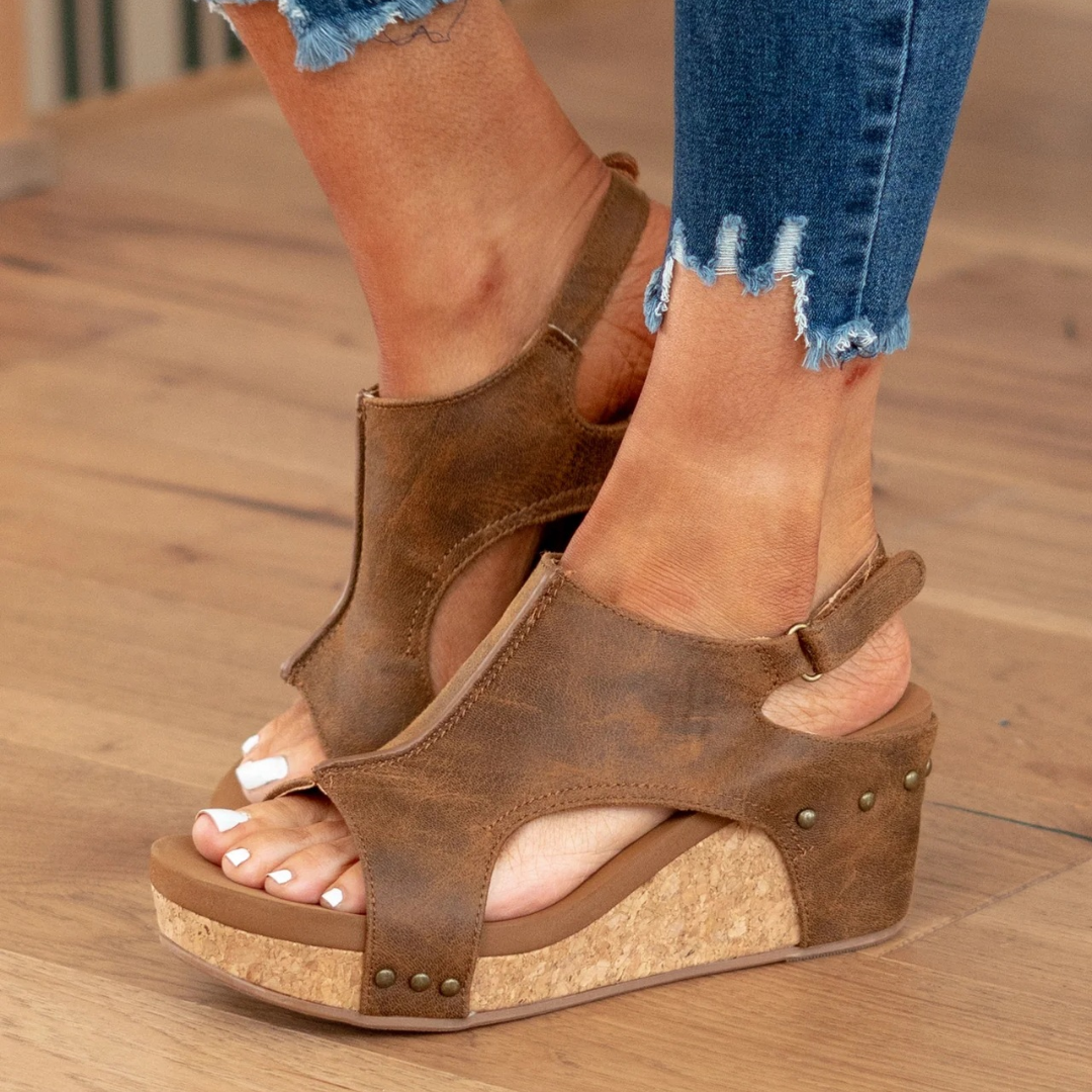 Side view of brown cutout wedge sandals with stacked cork heel