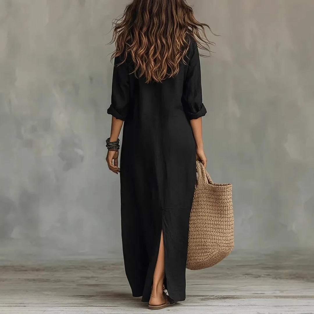 Back view of black maxi shirt dress with rolled sleeves and slit