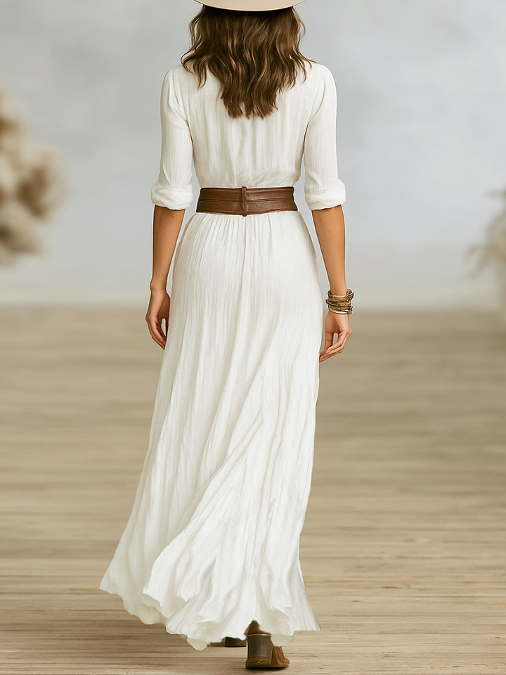 Back view of white maxi dress showing flowy skirt and brown belted waist