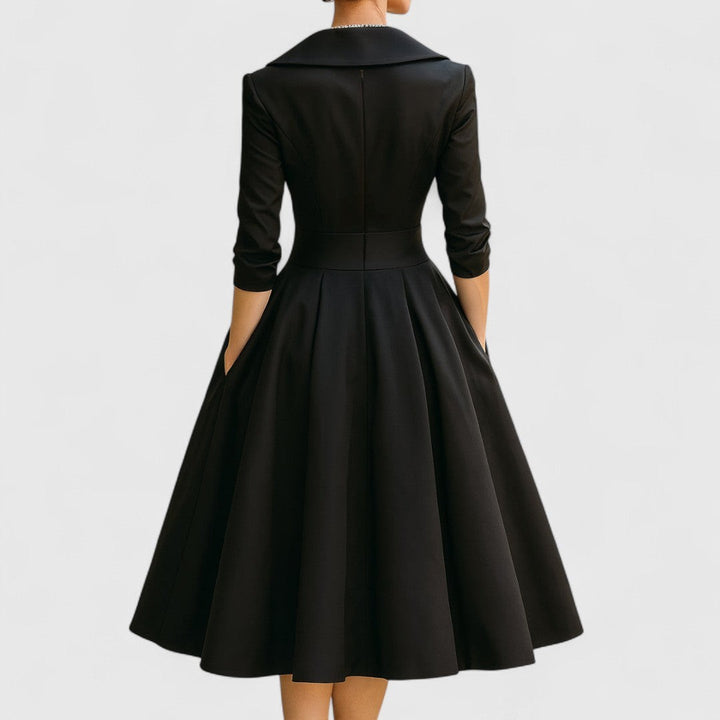 Back view of black satin midi dress with flared pleated skirt