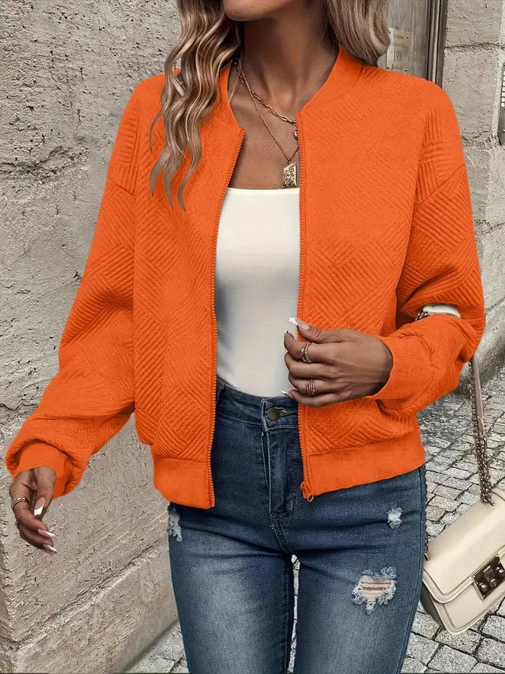 Orange zip-up bomber jacket showcasing a raised geometric weave