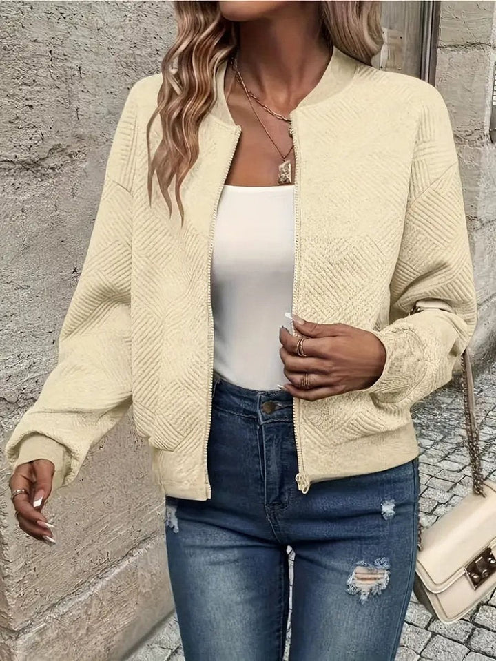 Cream textured zip-up bomber jacket layered over a white top