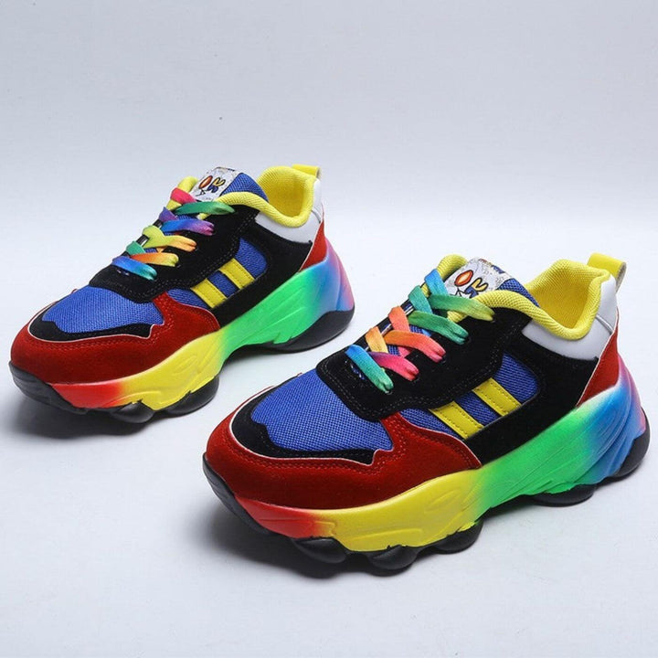 Pair of red, blue, and yellow chunky sneakers with rainbow platform sole