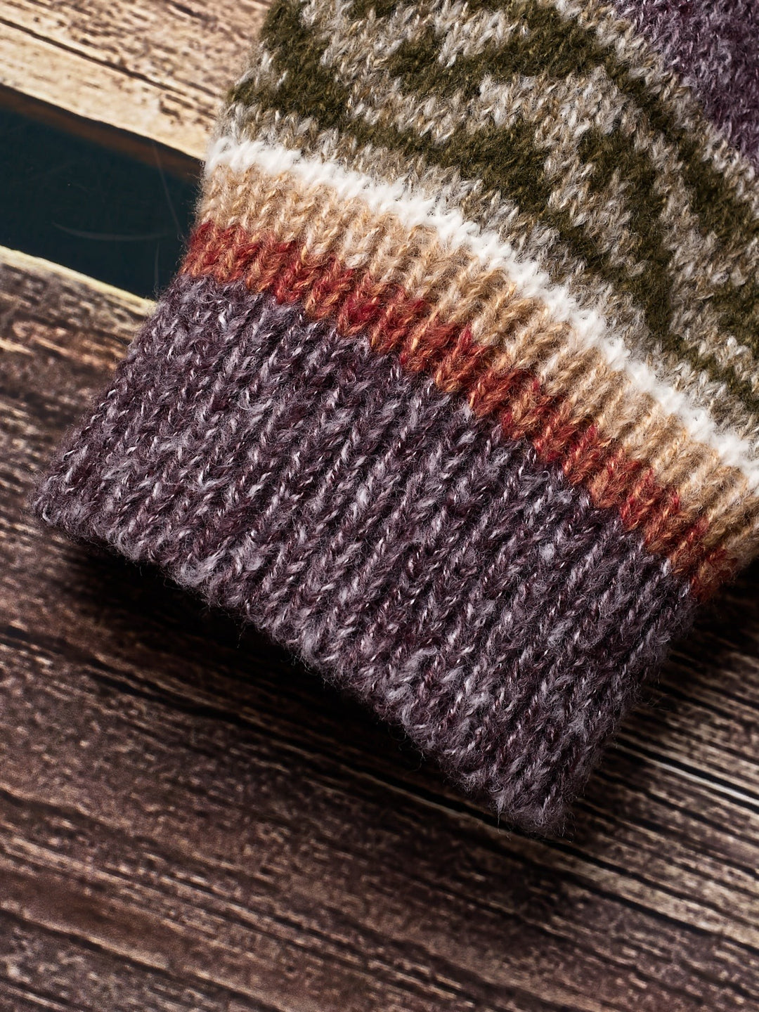 Folded purple knit fabric showing ribbed texture and colour blocking