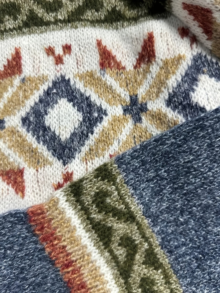 Close-up of Fair Isle knit pattern with blue diamonds on cream cardigan yoke