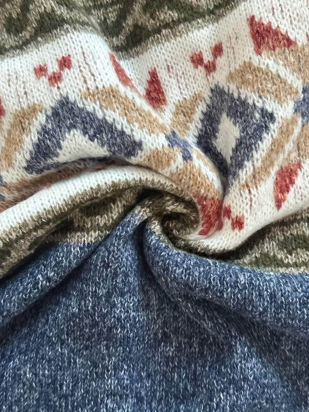Folded knit fabric showing colour-block detail on Fair Isle cardigan