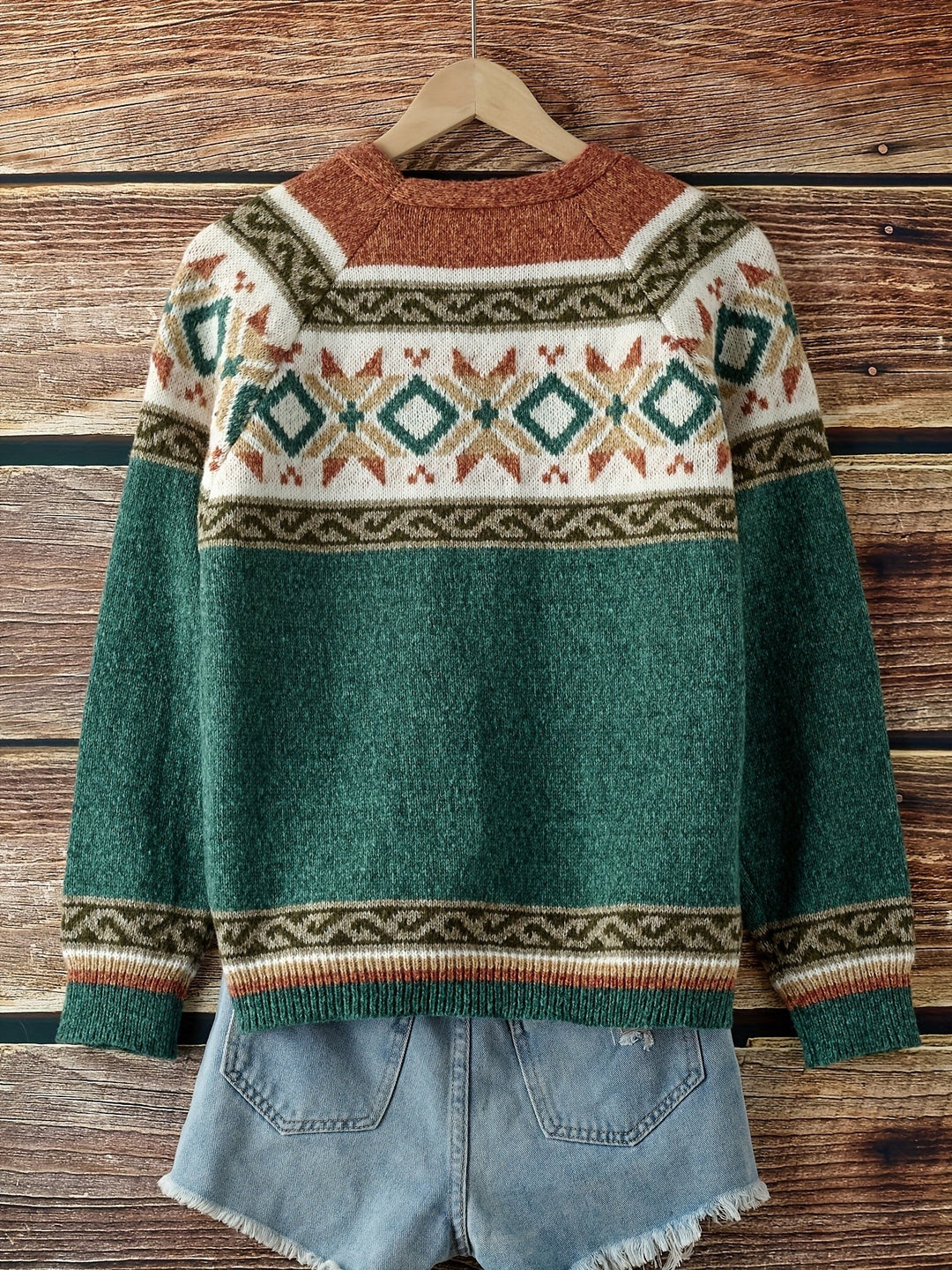 Teal Fair Isle cardigan back view hung on wooden hanger, diamond motif yoke