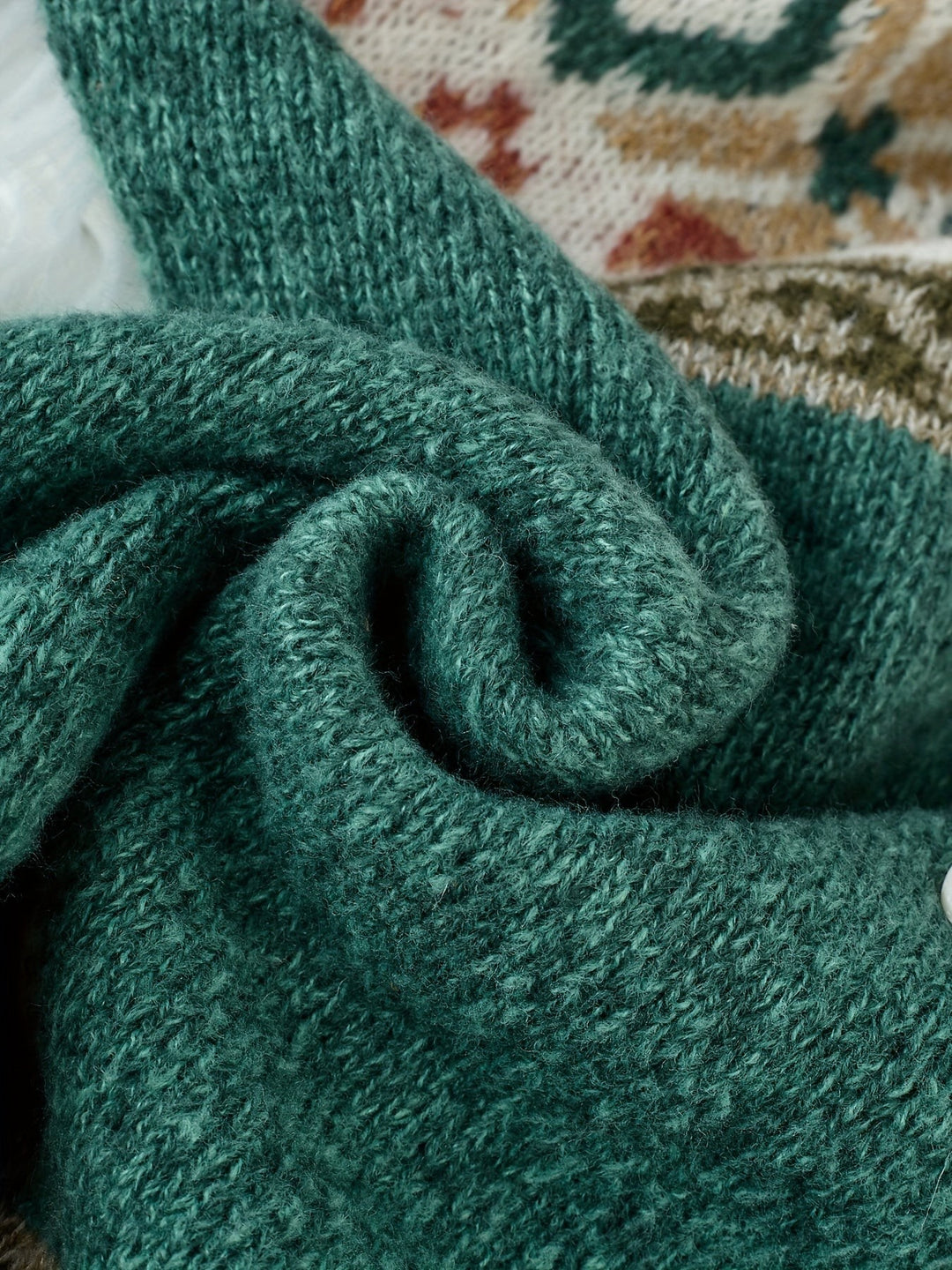 Teal knit cardigan fabric close-up showing chunky ribbed texture