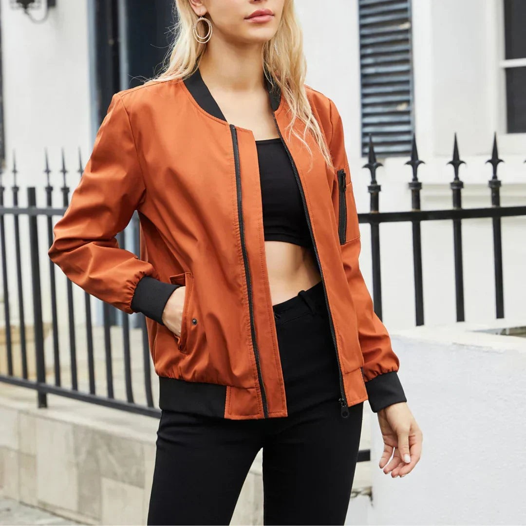 Rust orange bomber jacket featuring black ribbed collar and cuffs