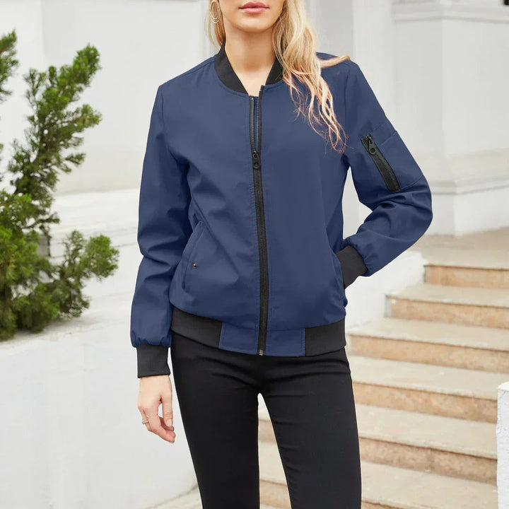 Navy blue bomber jacket with black ribbed trim and zip pockets