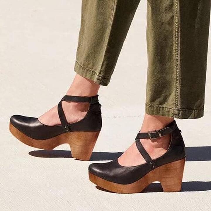 black leather wedge heels with crisscross ankle straps and wooden platform