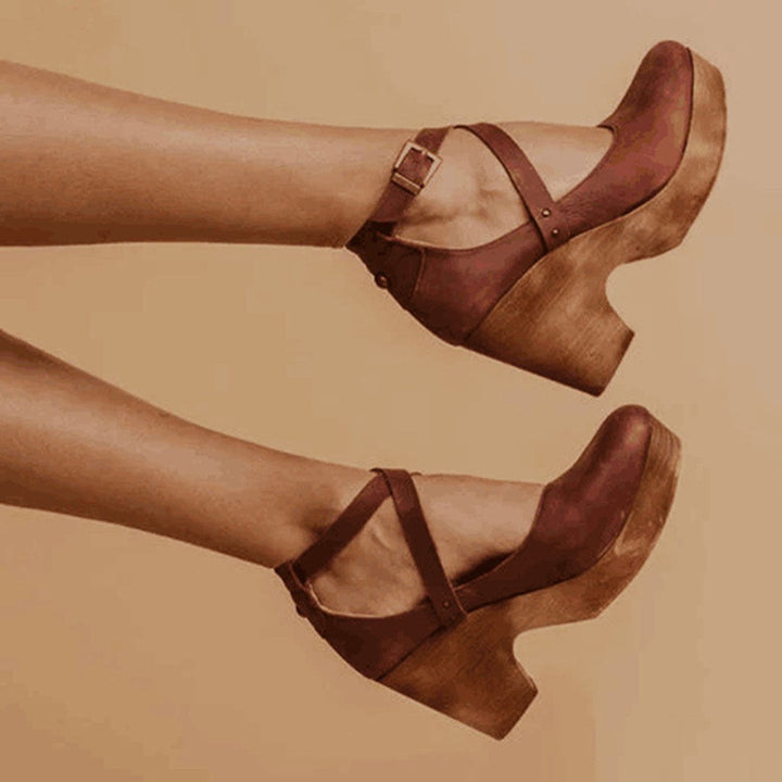 brown leather wedge heels featuring crisscross straps and chunky wooden sole