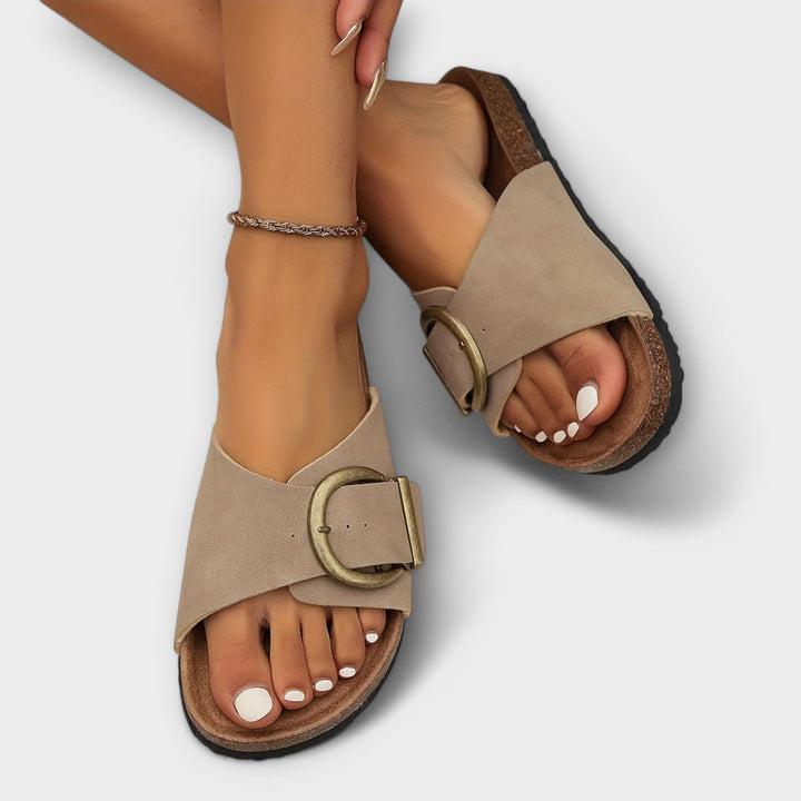 Taupe slide sandals with crisscross strap and antique gold buckle accent