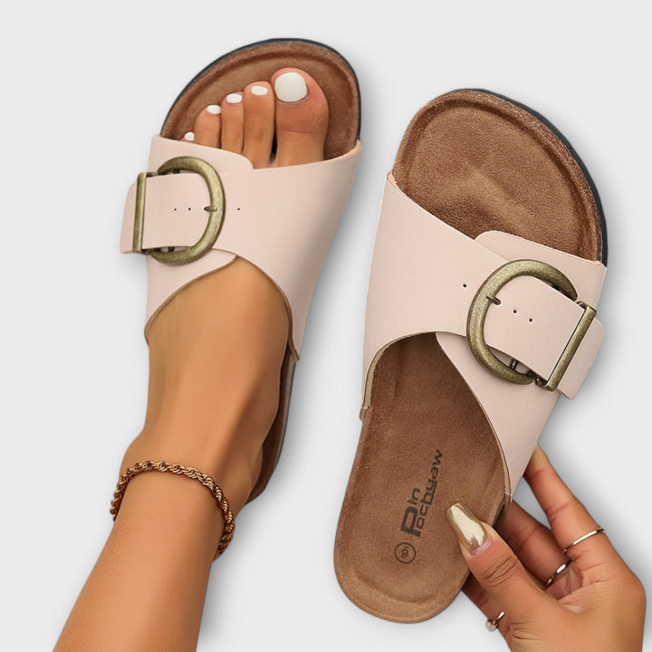 Blush pink slide sandals with large gold buckle and cork platform sole