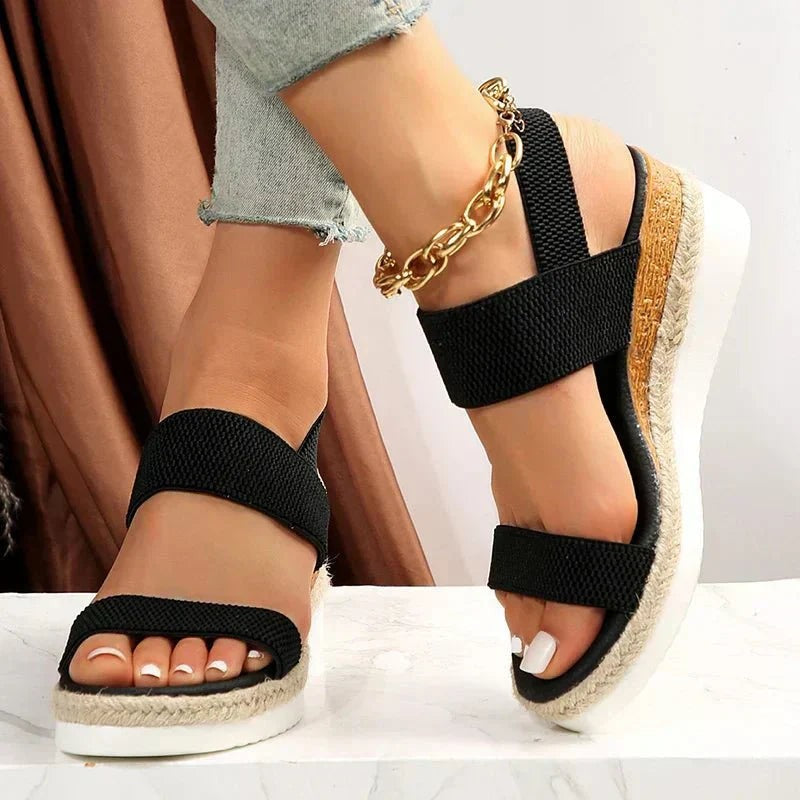 Black platform wedge sandal with wide elastic straps and braided jute trim