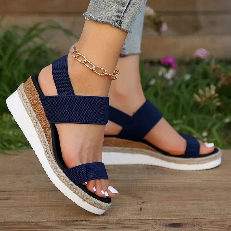 Navy blue wedge sandal featuring open toe strap and jute platform sole