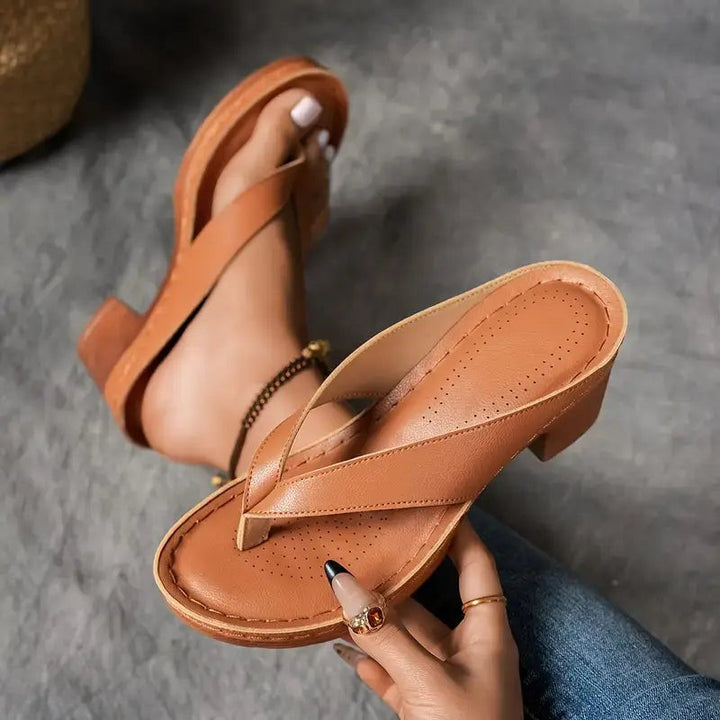 Cognac brown leather thong sandal showing cushioned footbed and stitched strap