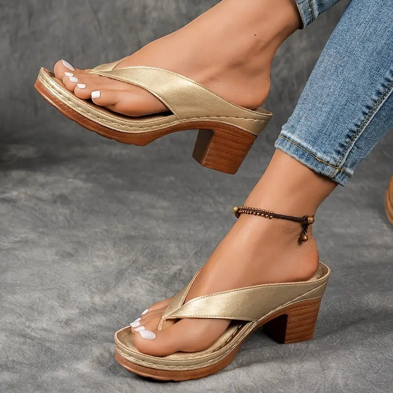 Gold block-heel flip-flop sandals worn on foot with crossover strap design